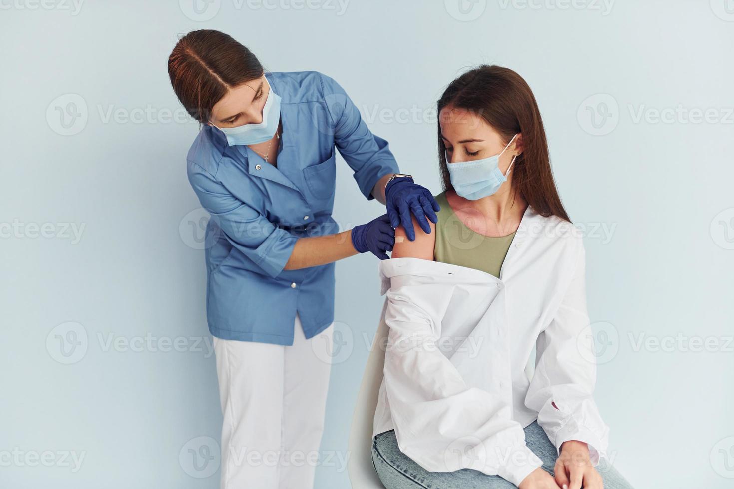 Using syringe. Doctor in uniform making vaccination to the patient photo