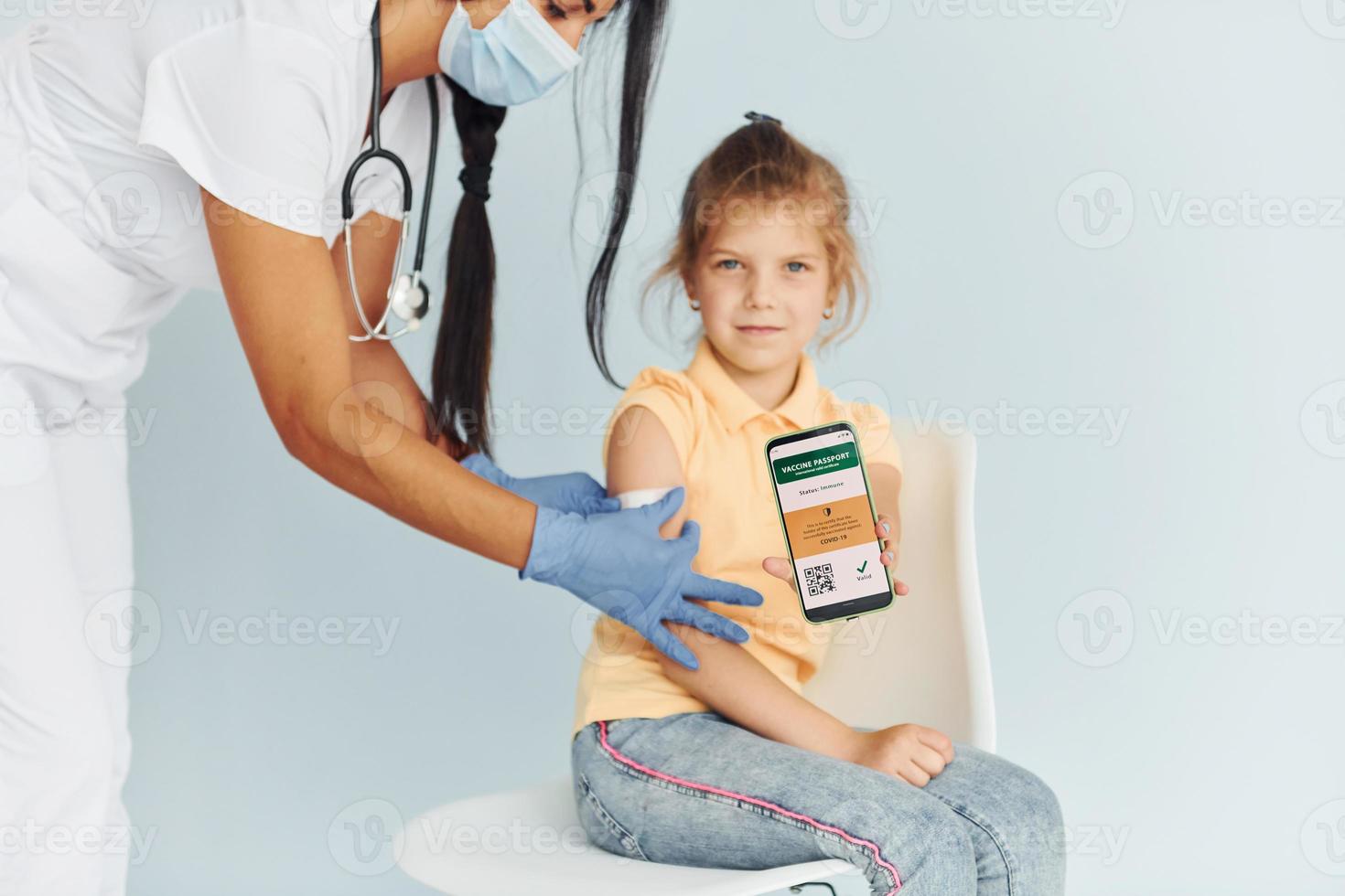 Doctor in uniform making vaccination to the little girl photo