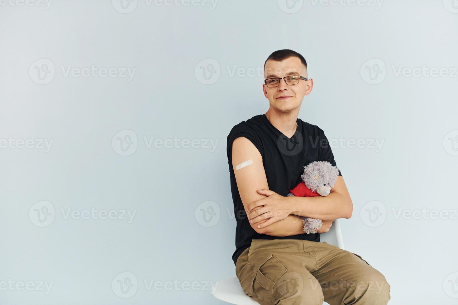 Portrait of man in black shirt that sitting after vaccination photo