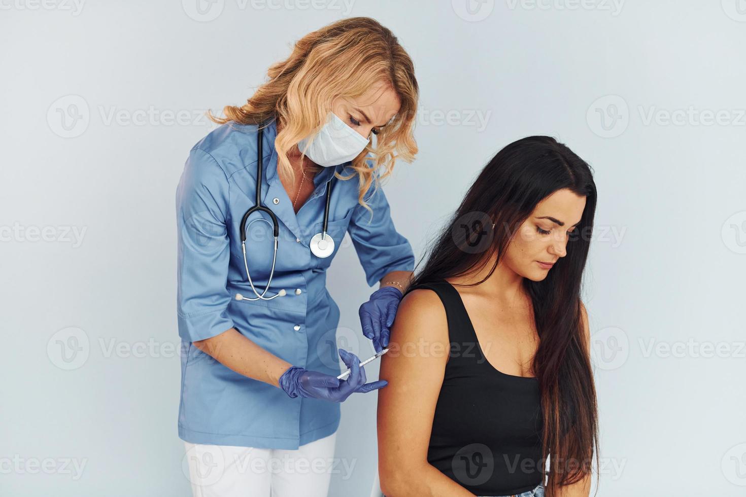 Succesfull procedure. Doctor in uniform making vaccination to the patient photo