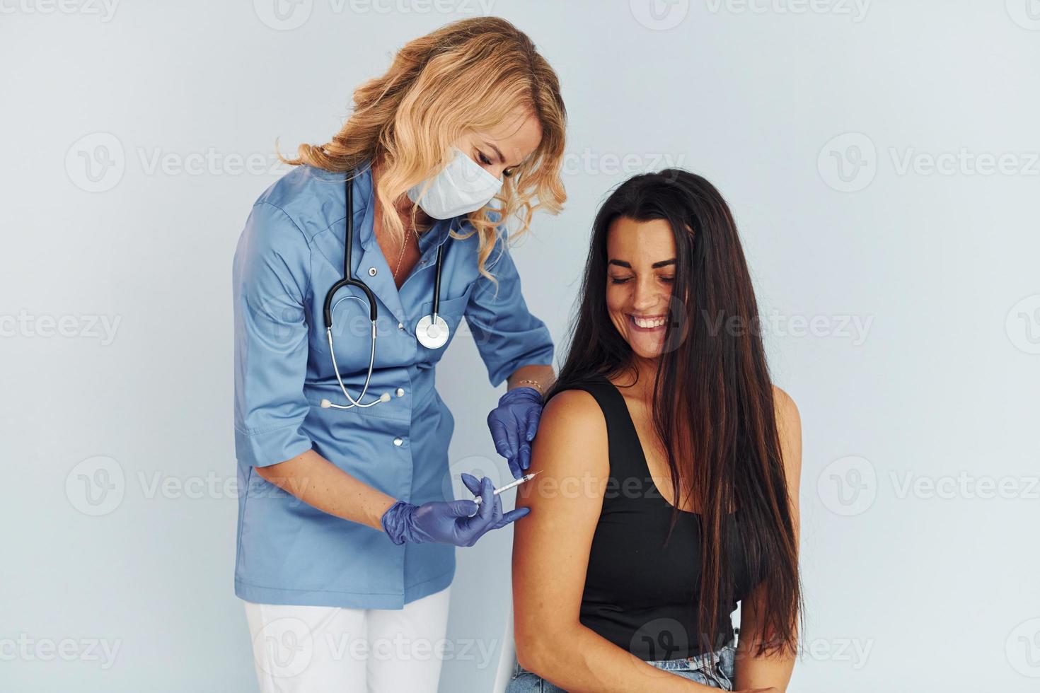 Succesfull procedure. Doctor in uniform making vaccination to the patient photo