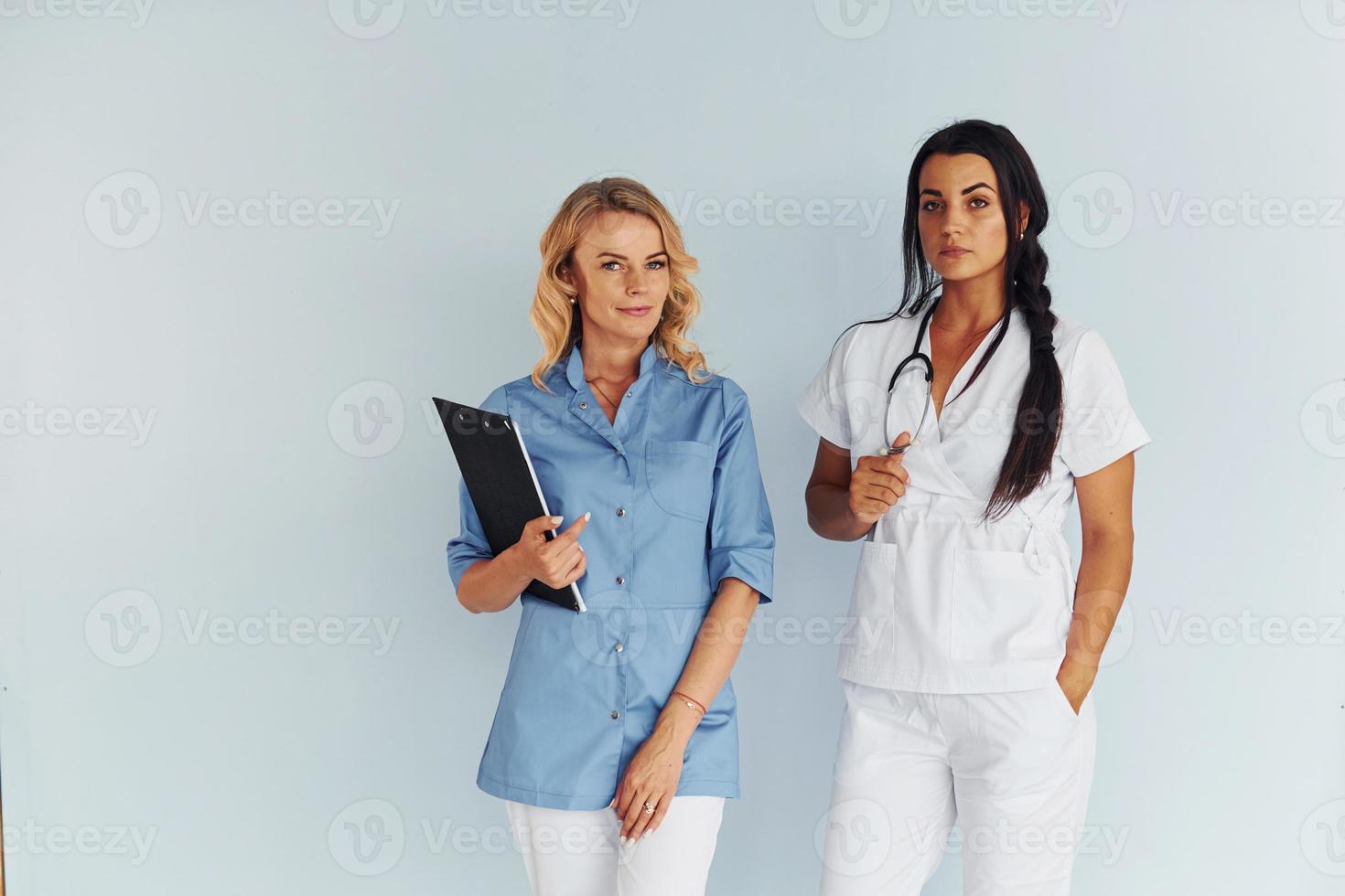 Two doctors in uniform standing indoors and working together photo