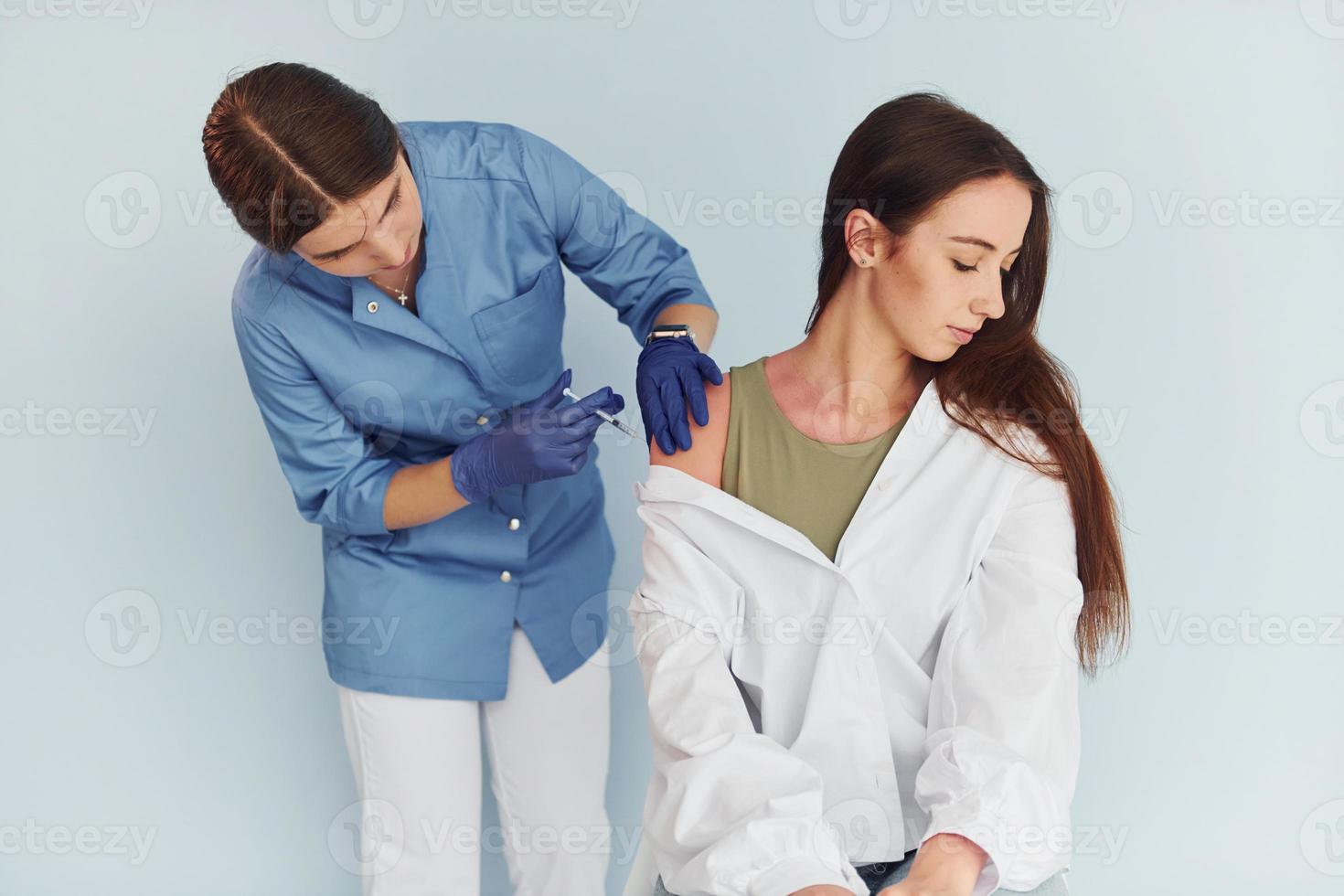 SImple but effective procedure. Doctor in uniform making vaccination to the patient photo