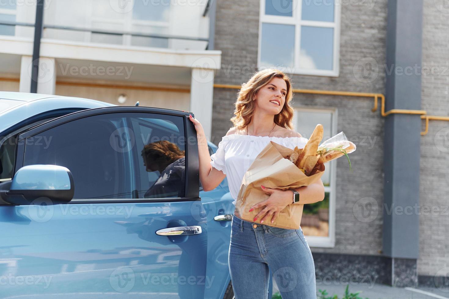 After shopping. Young woman in casual clothes with her electromobile outdoors at daytime photo