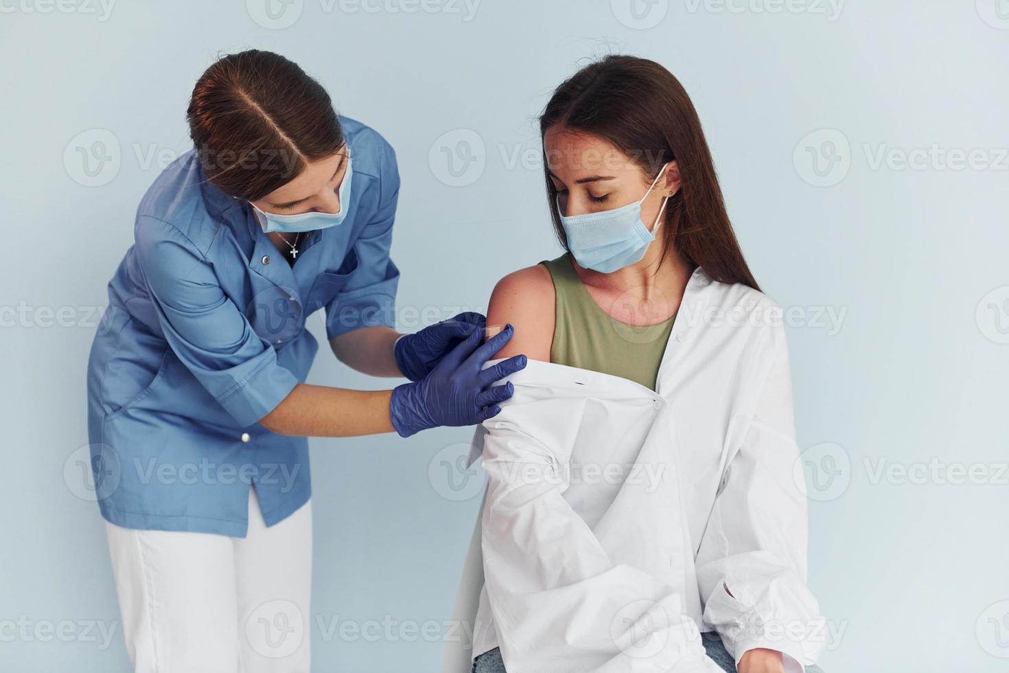 SImple but effective procedure. Doctor in uniform making vaccination to the patient photo