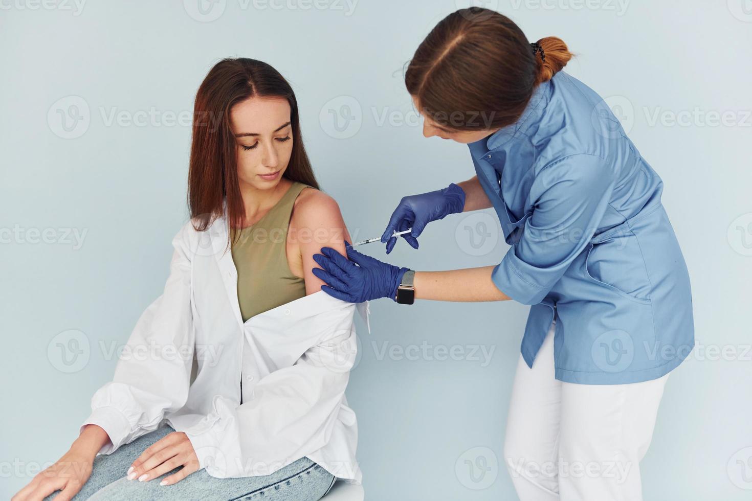 SImple but effective procedure. Doctor in uniform making vaccination to the patient photo