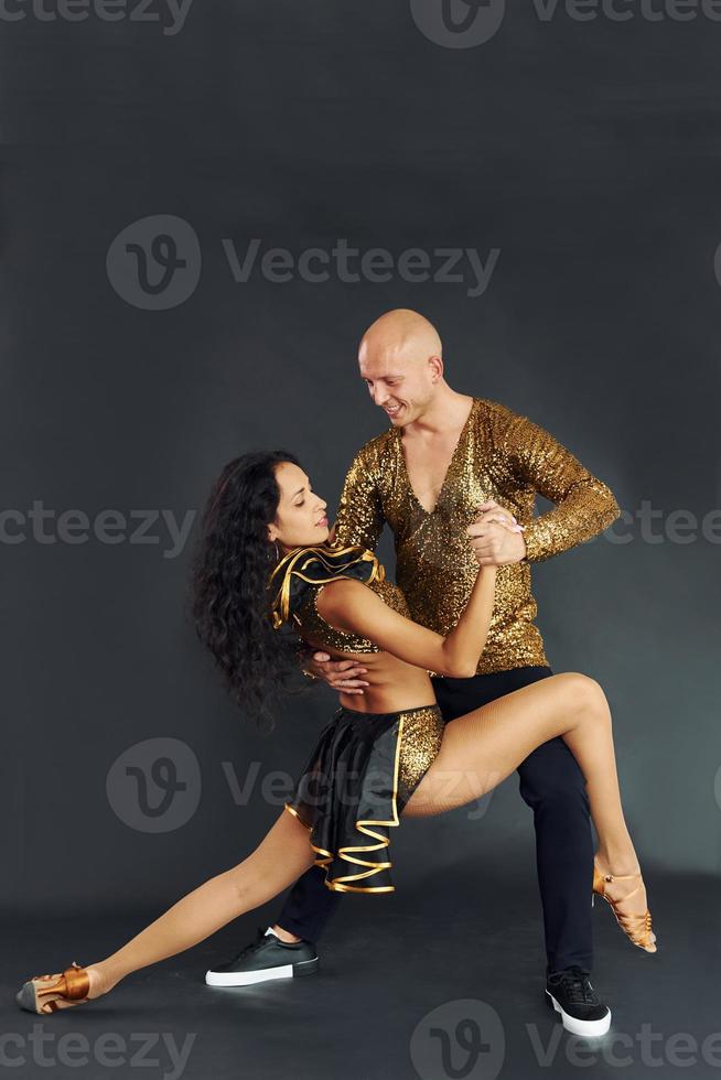 Against black background. Cheerful couple is together indoors photo