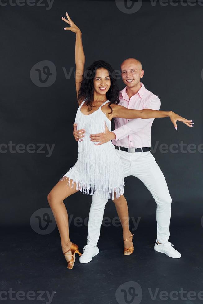 bailando en el estudio. una pareja alegre está junta en el interior foto