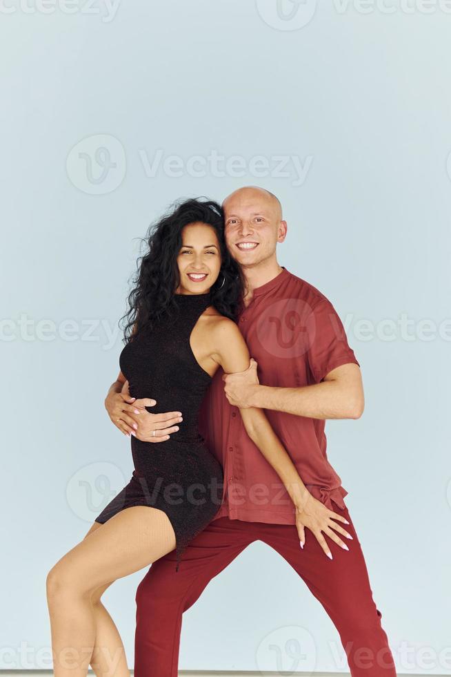 en ropa negra y roja. una pareja alegre está junta en el interior foto