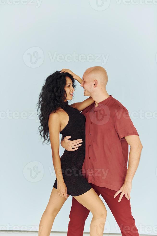 In black and red clothes. Cheerful couple is together indoors photo