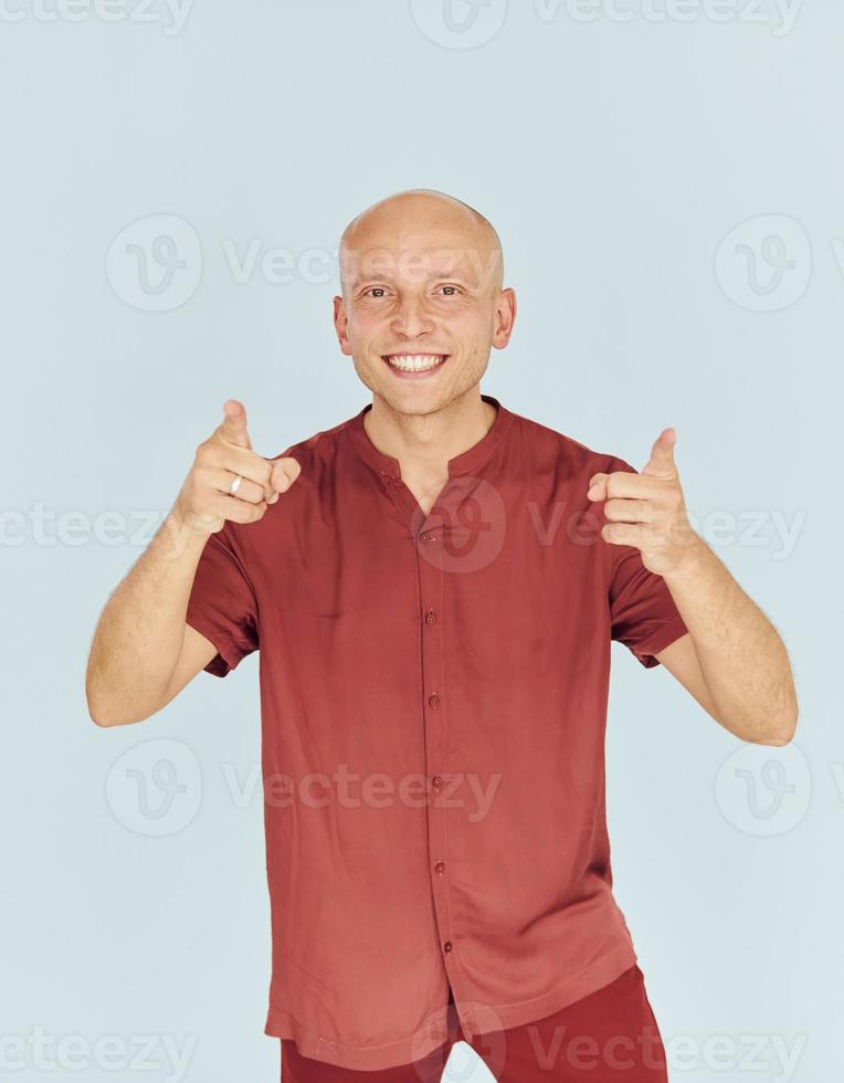 el hombre con camisa casual roja está de pie contra el fondo blanco foto