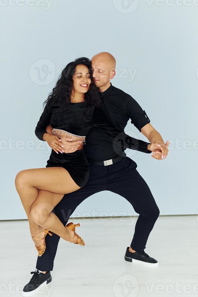 Against white background. Cheerful couple is together indoors photo