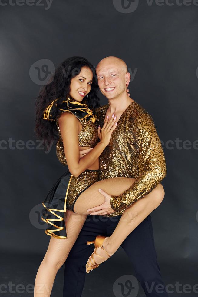 Side view of people dancing. Cheerful couple is together indoors photo