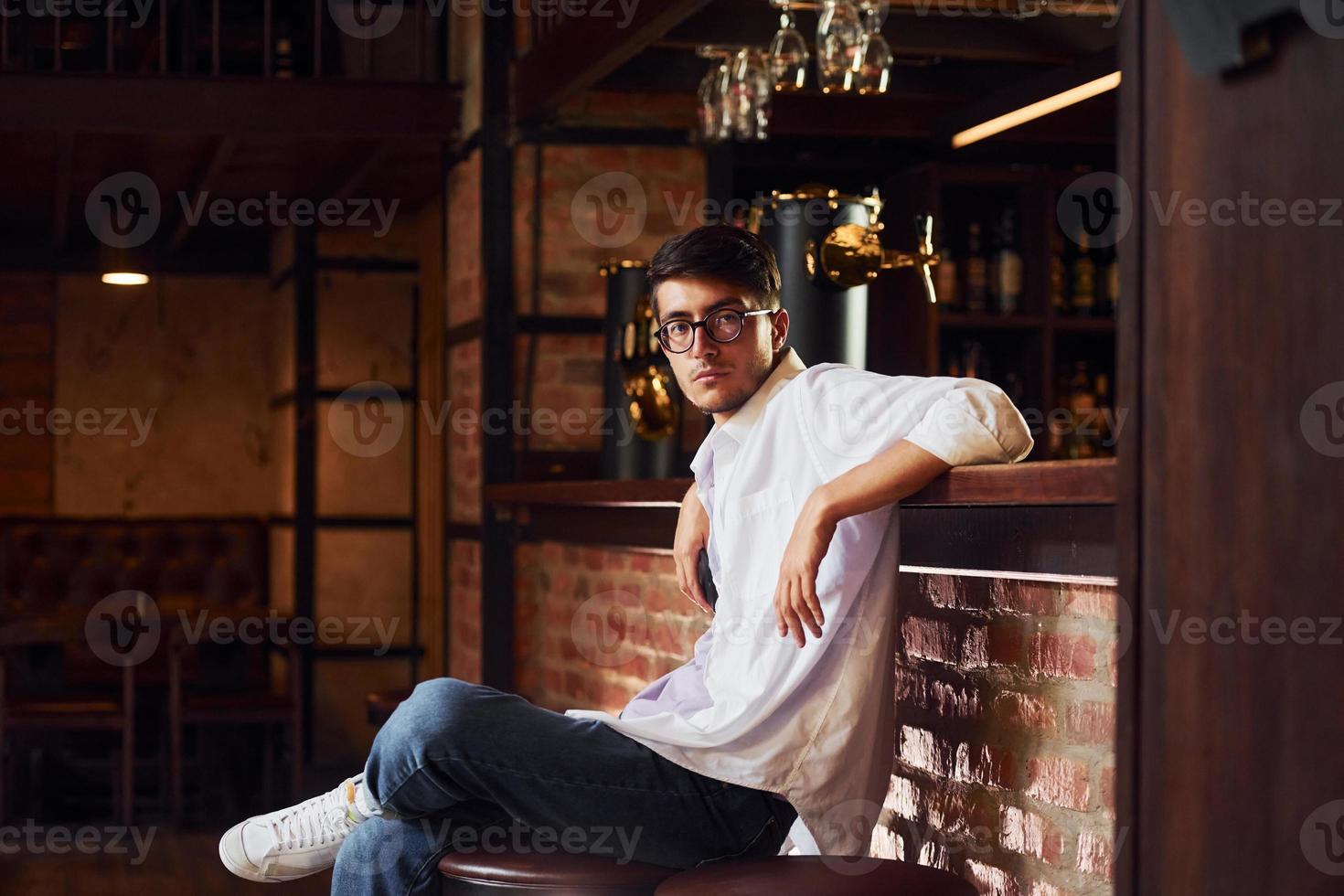 barra de pub. hombre con ropa informal sentado en el interior foto