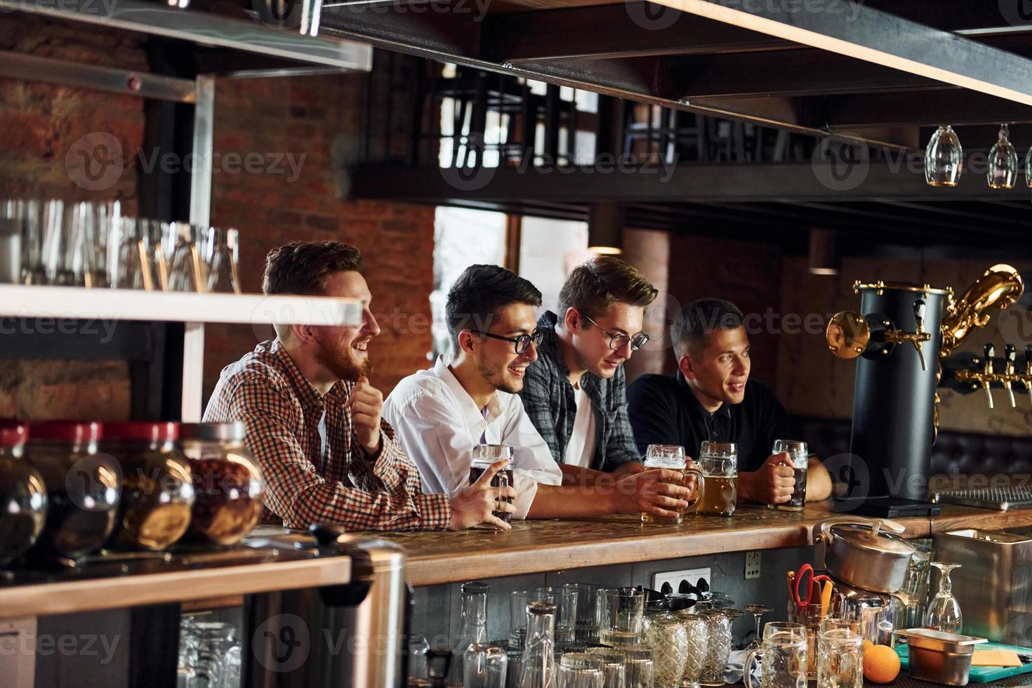 Football fans. People in casual clothes sitting in the pub photo