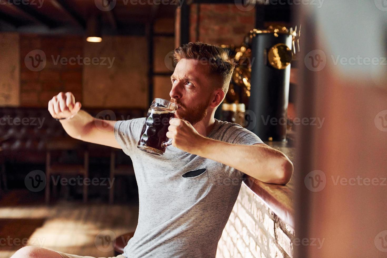 Man in casual clothes sitting in the pub at daytime photo