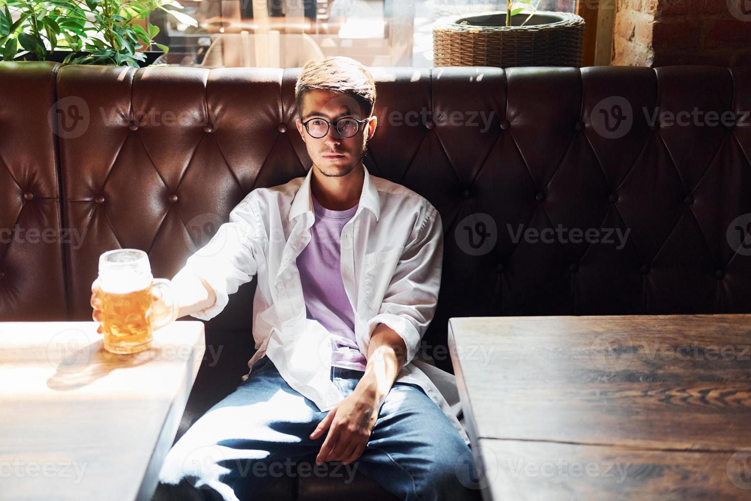 hermoso interior hombre con ropa informal sentado en el pub foto