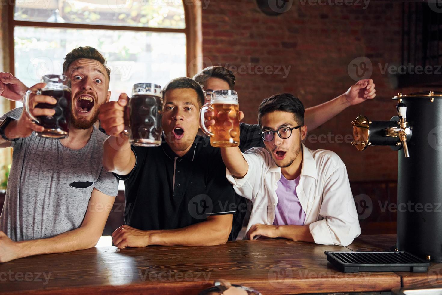 Soccer fans. People in casual clothes sitting in the pub photo