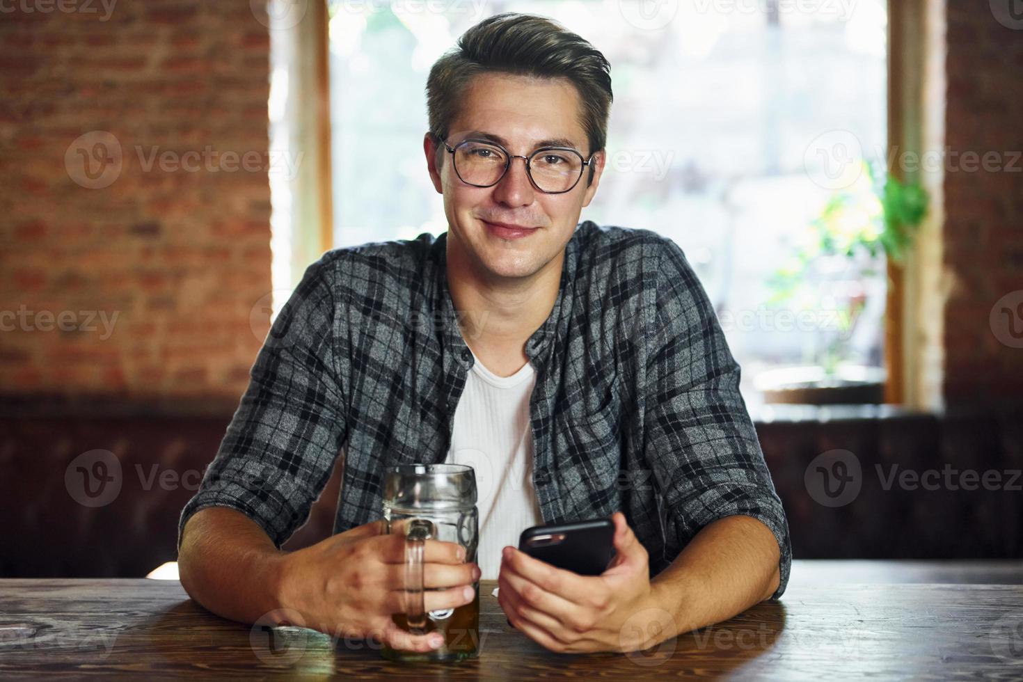 Beautiful interior. Man in casual clothes sitting in the pub photo