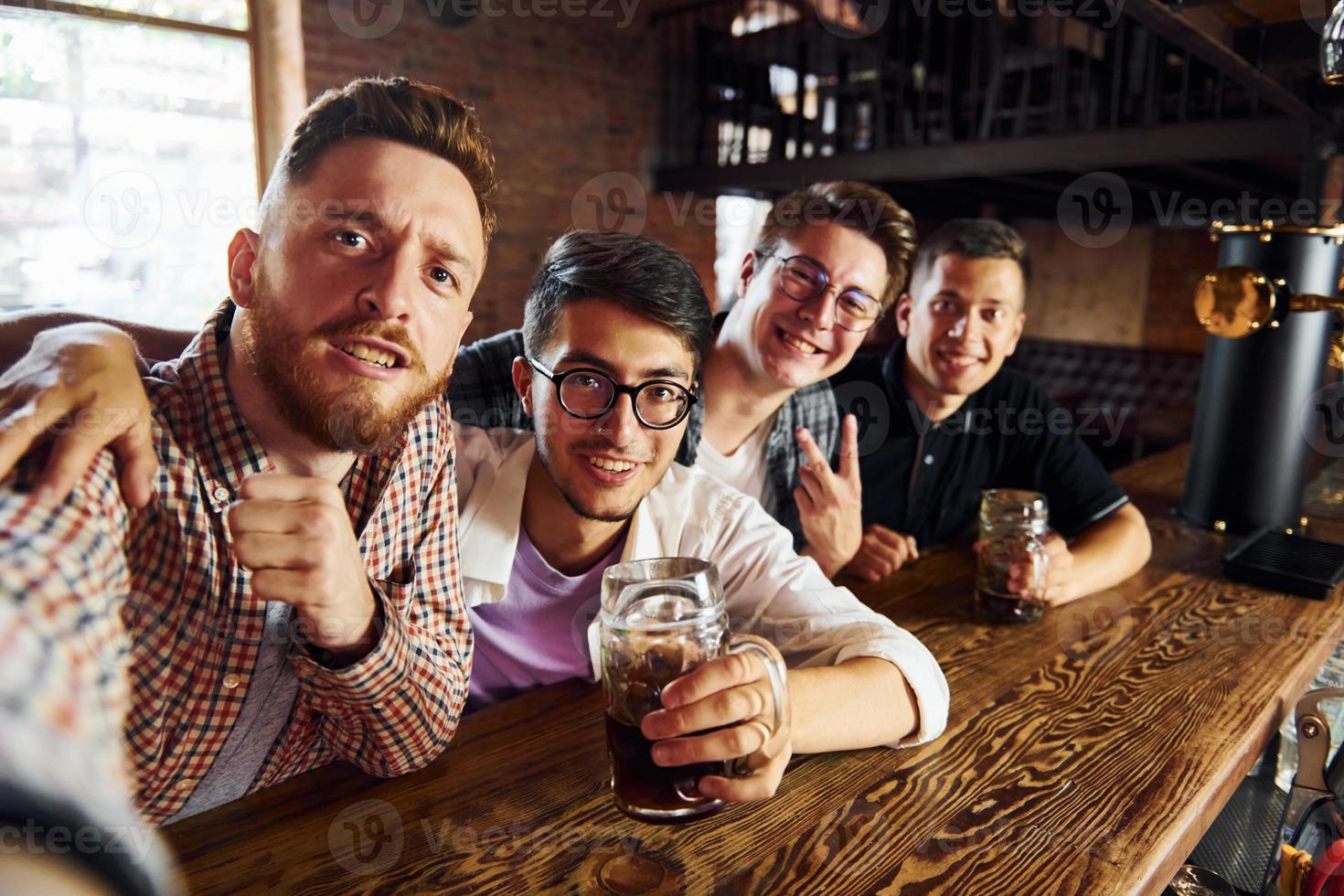 Making selfie. People in casual clothes sitting in the pub photo