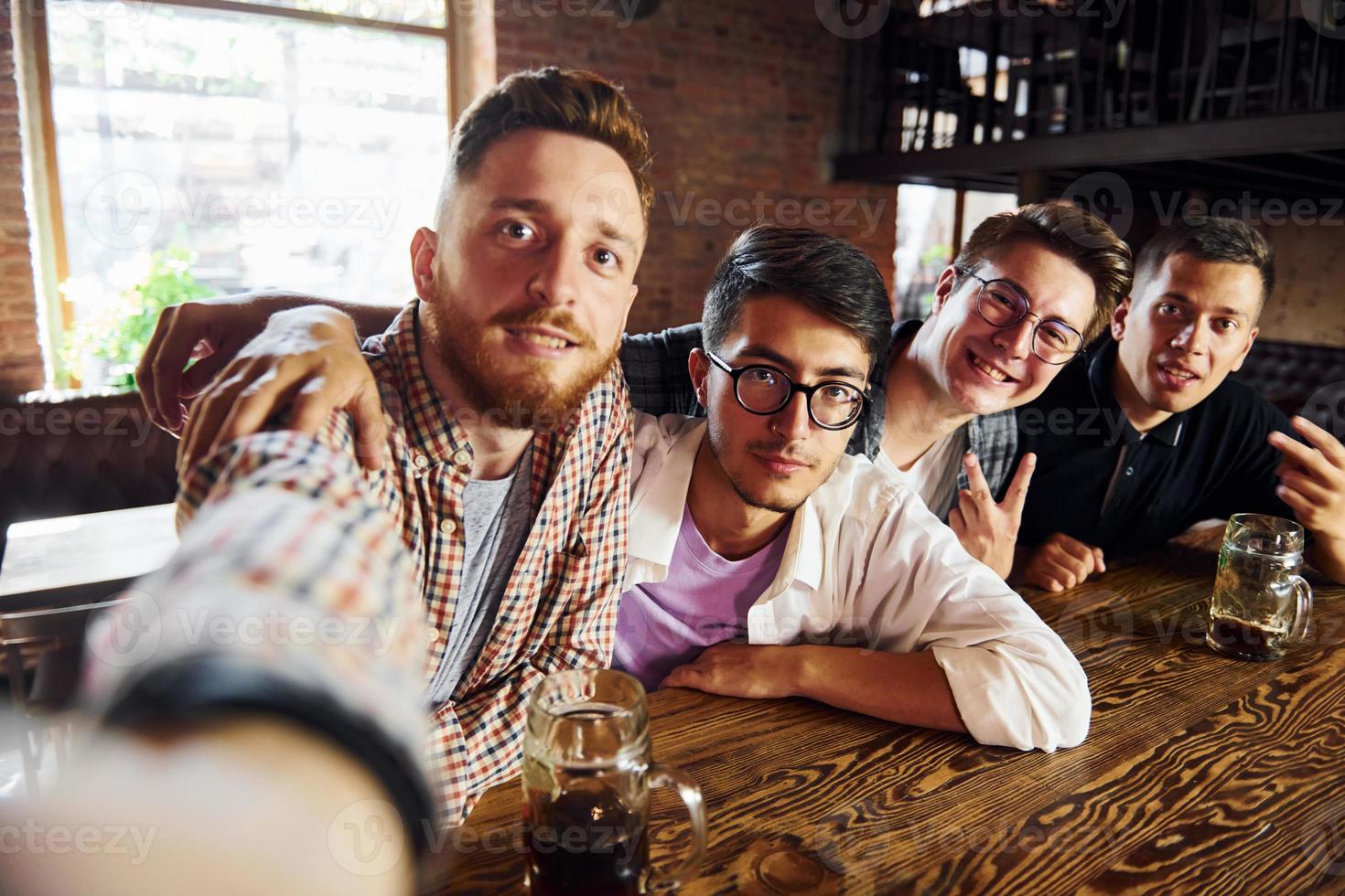 Making selfie. People in casual clothes sitting in the pub photo