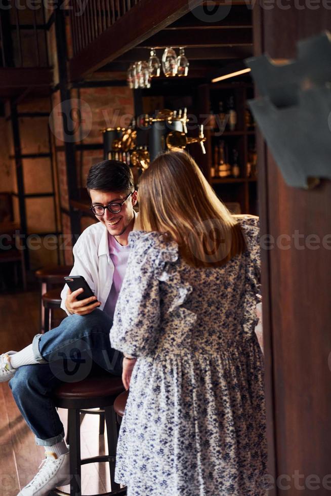 jóvenes alegres con ropa informal sentados en el pub foto