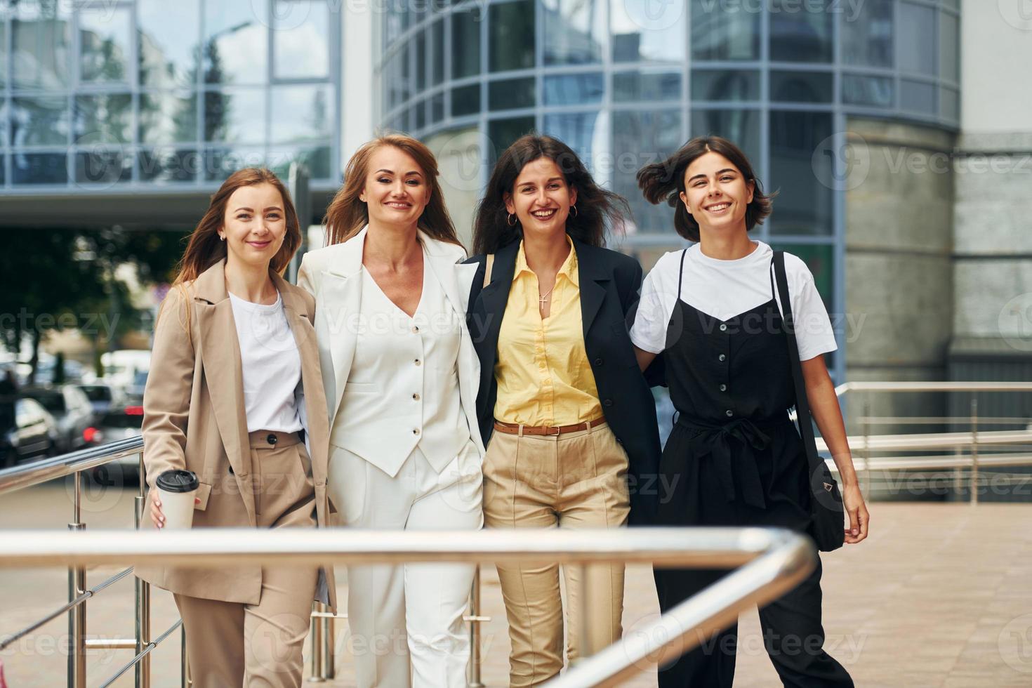 de pie juntos las mujeres en ropa formal están al aire libre en la ciudad foto