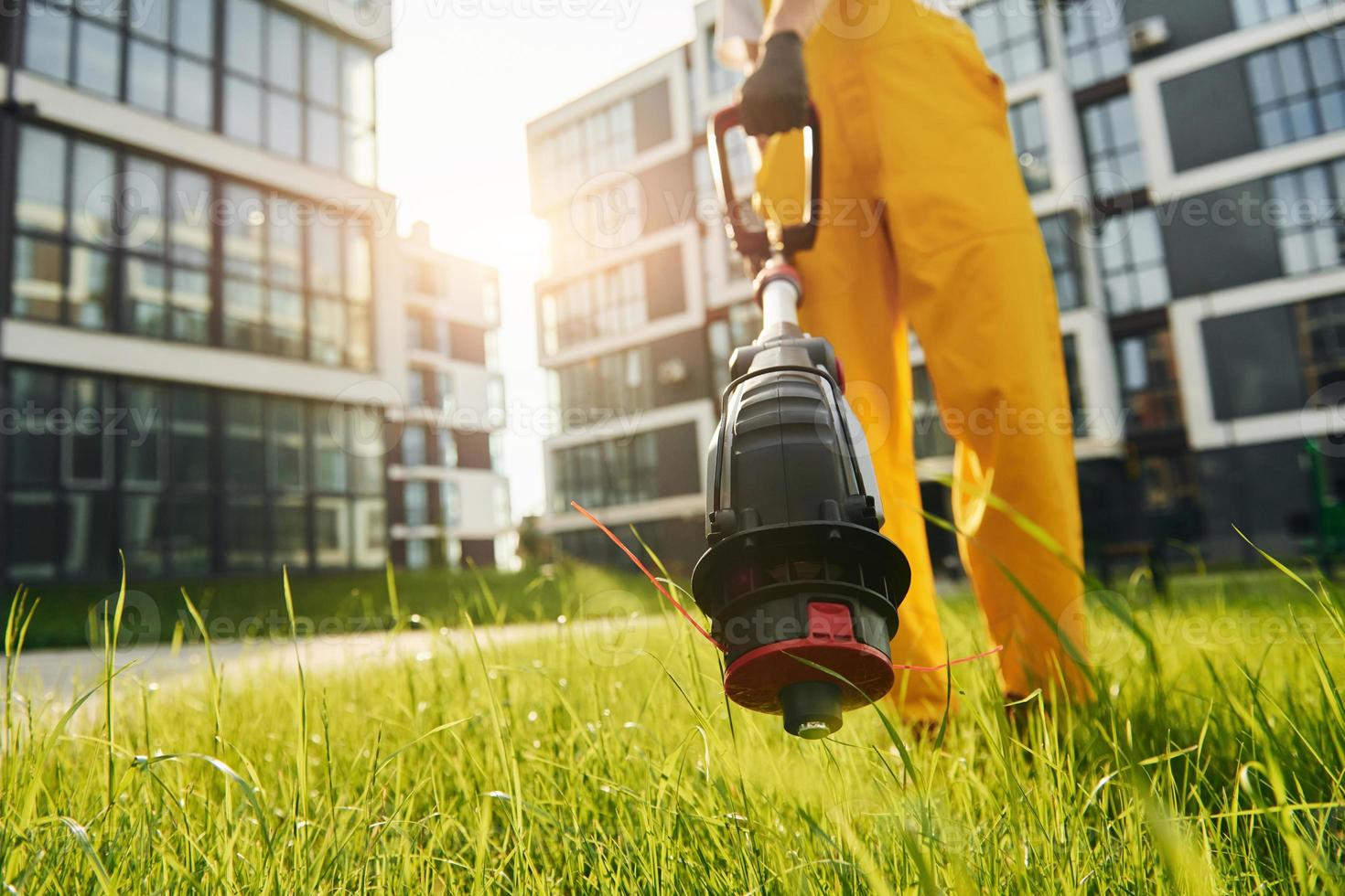 Beautiful sunshine. Man cut the grass with lawn mover outdoors in the yard photo