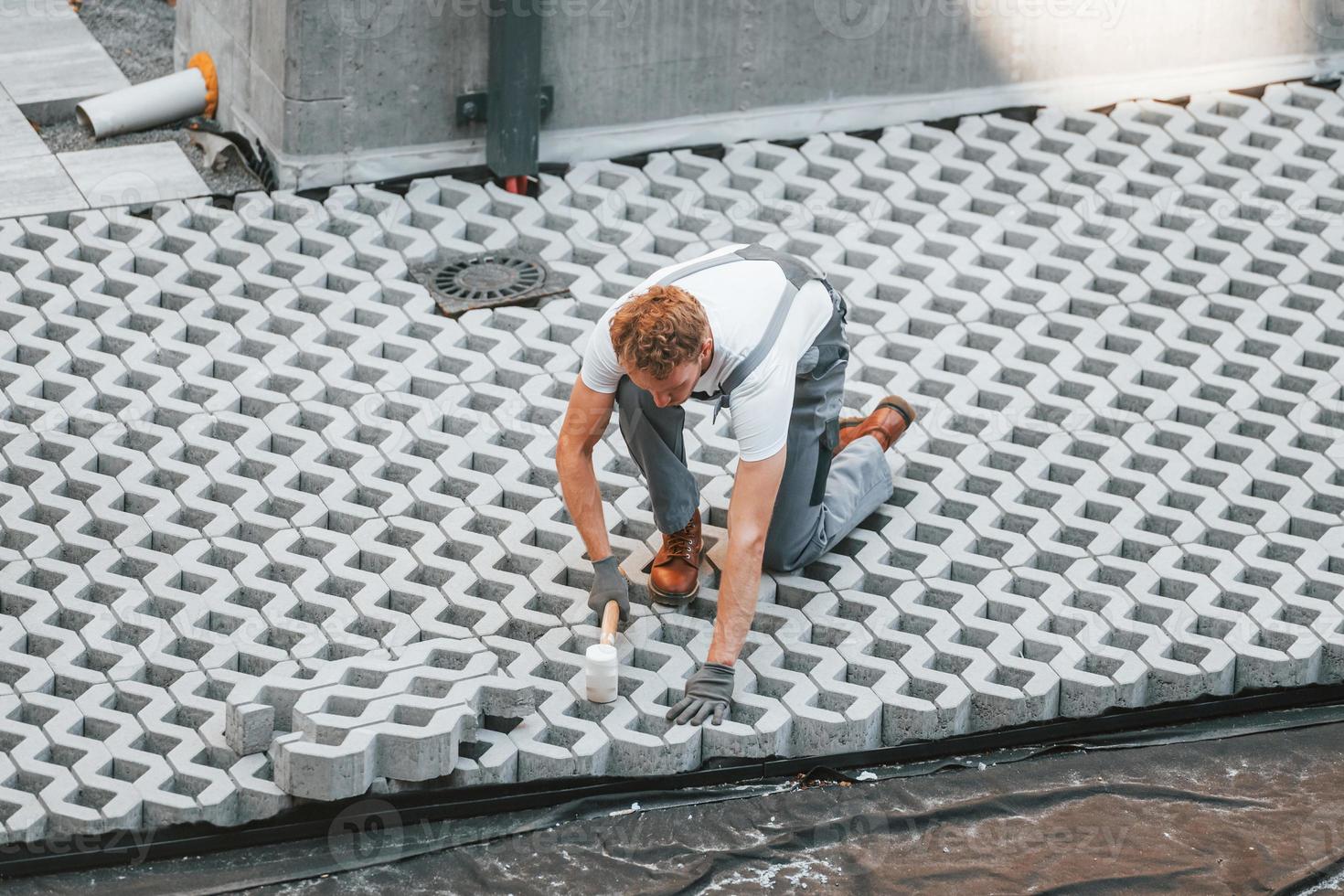 trabajo al aire libre. joven que trabaja en uniforme en la construcción durante el día foto