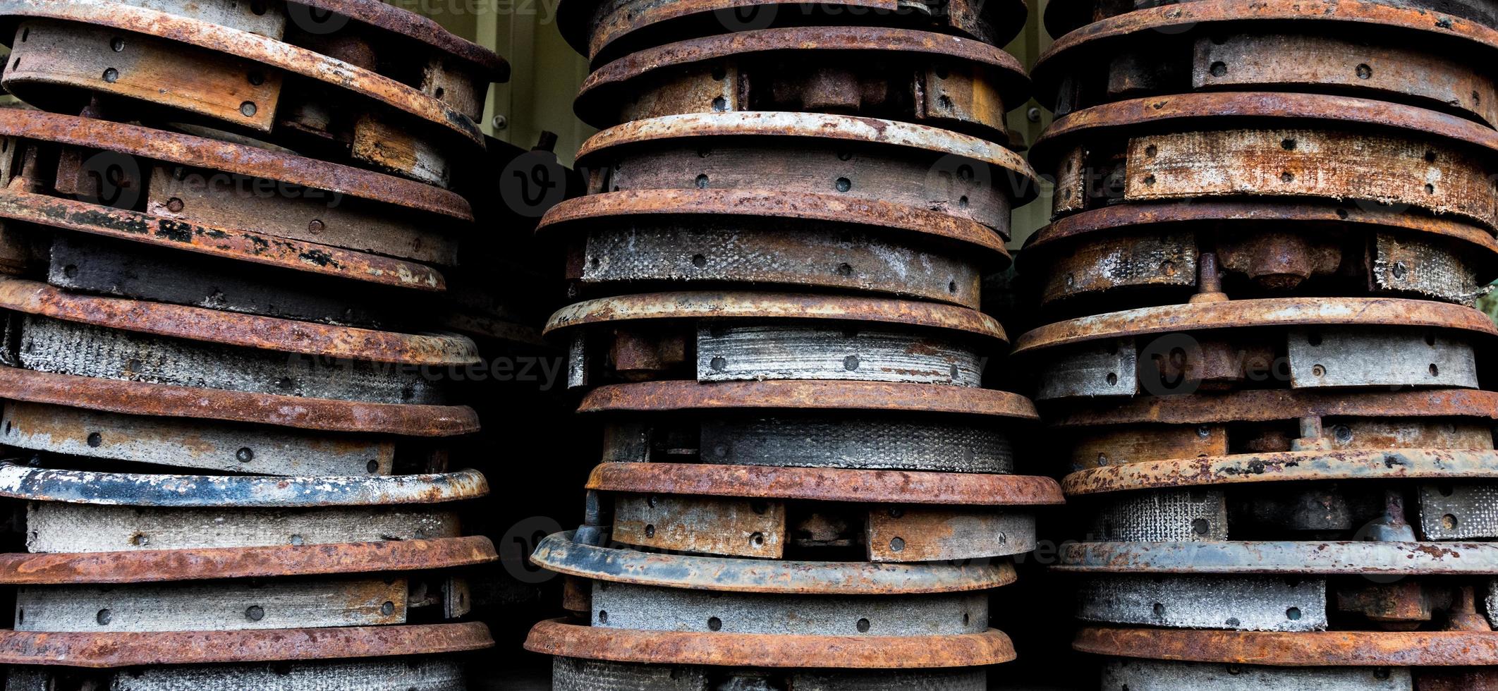 Vintage antique automotive brake shoes connected to backing plates in a pile photo