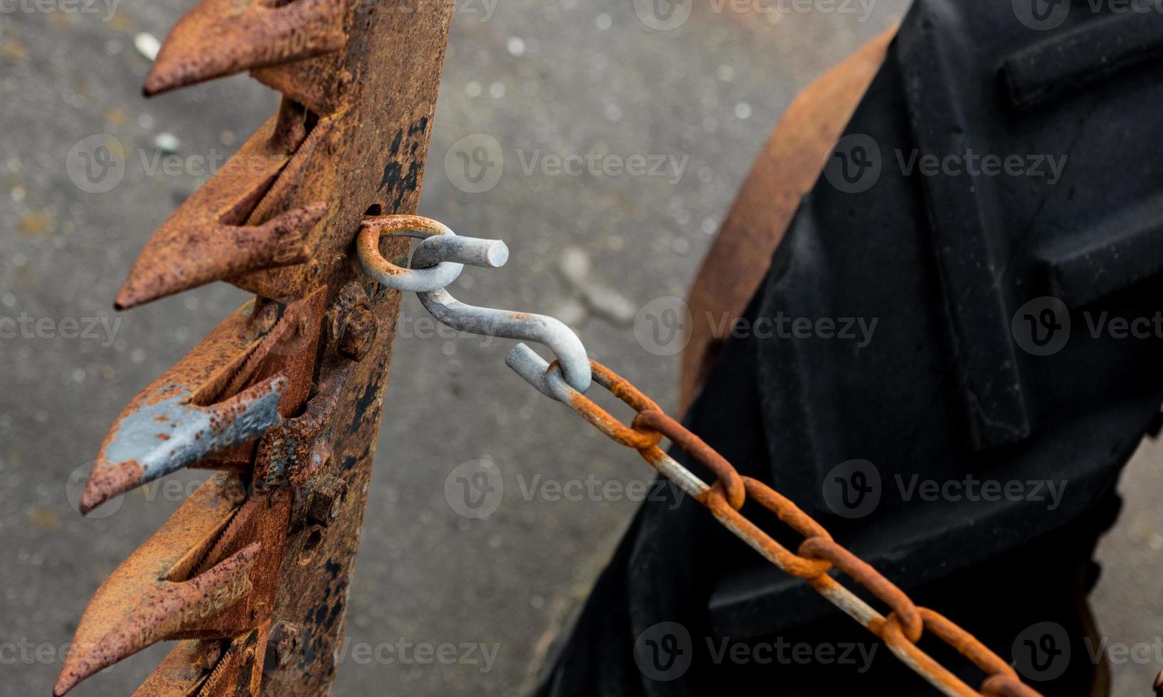 Vintage antique automotive tractor wheel and cutter implement and chain showing rust photo