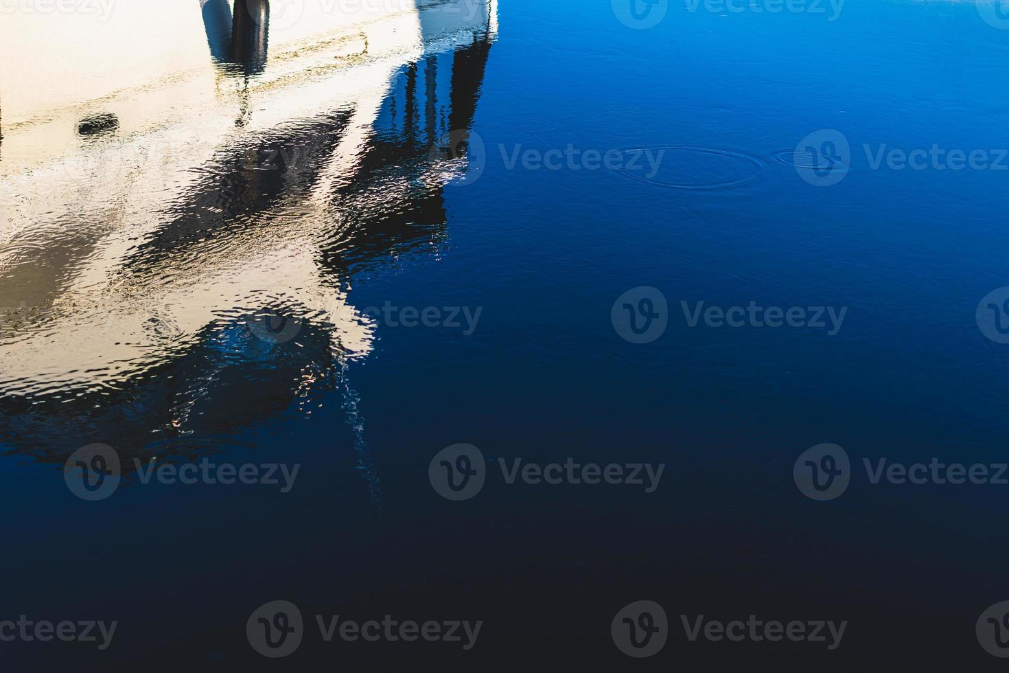 Abstract boat reflection on a deep blue dark harbor photo