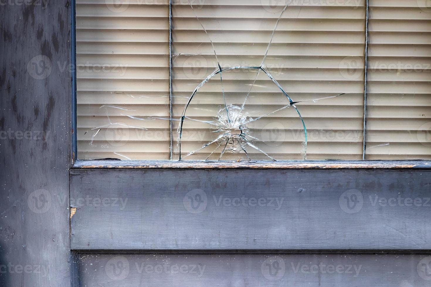 Abstract old building storefront window with bullet hole photo