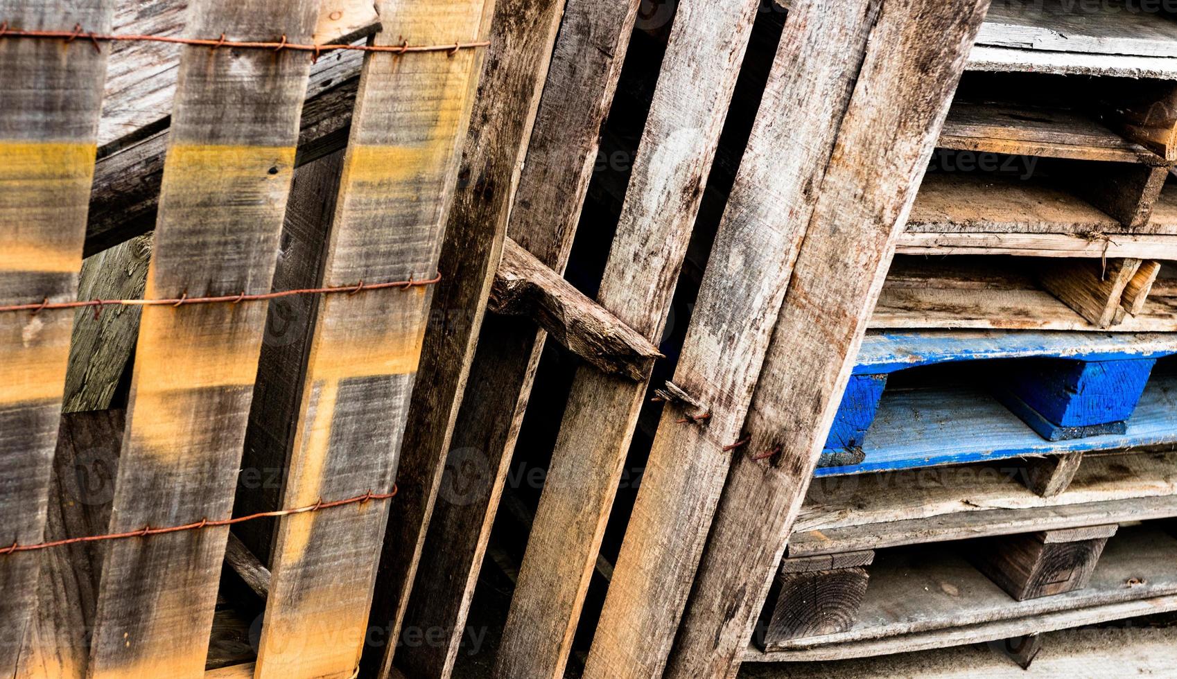 Decomposing wooden box and stacked pallets with paint and age photo
