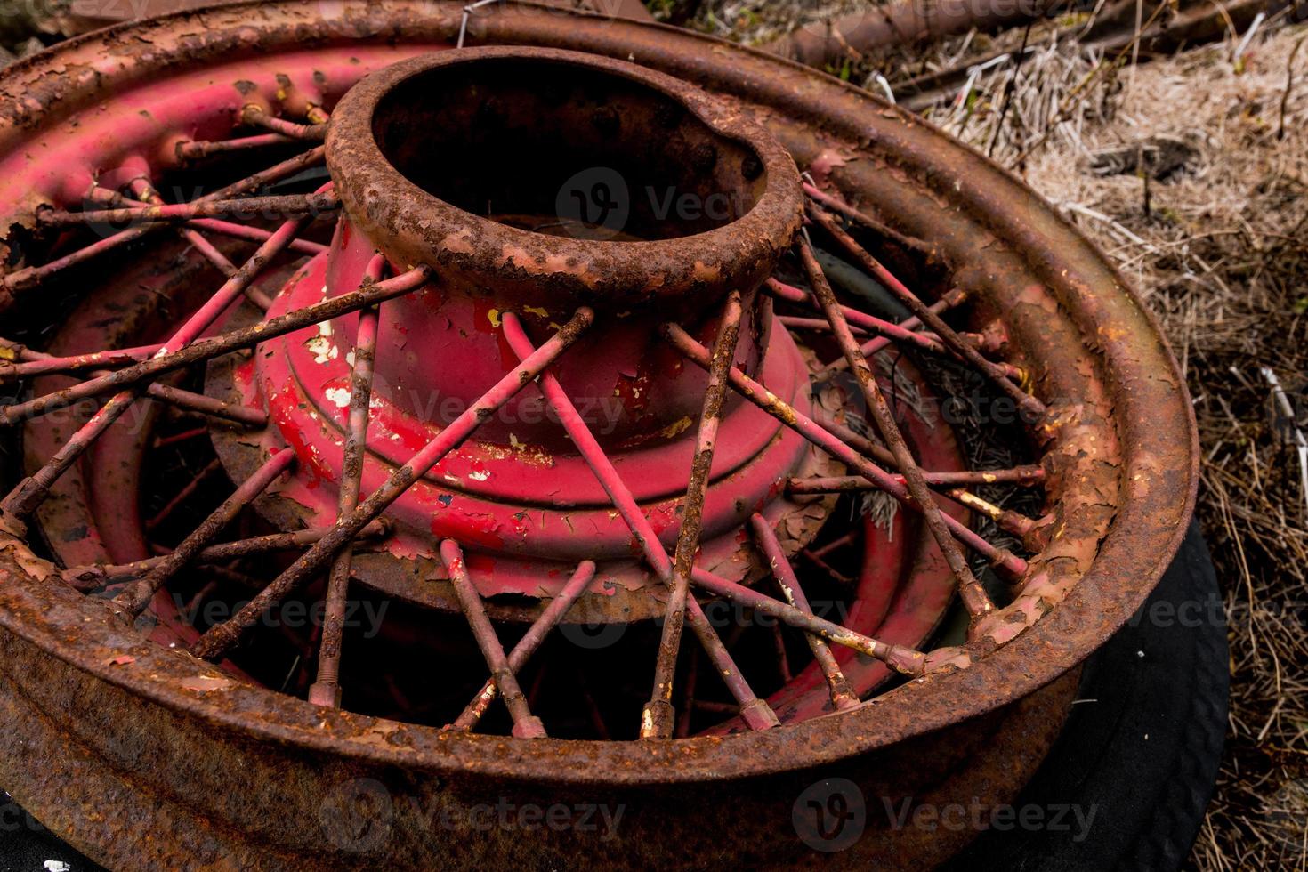 Vintage antique automotive wire wheel spokes and hub with red peeling paint and rust photo