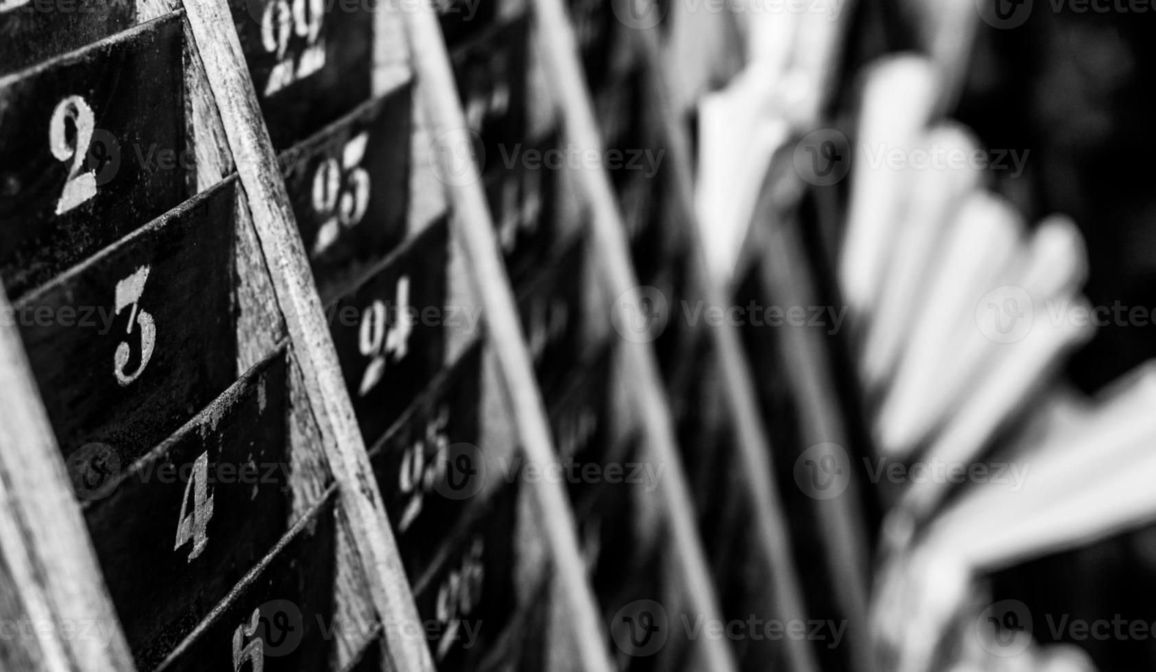Numbered old and faded time clock punch card wall rack photo