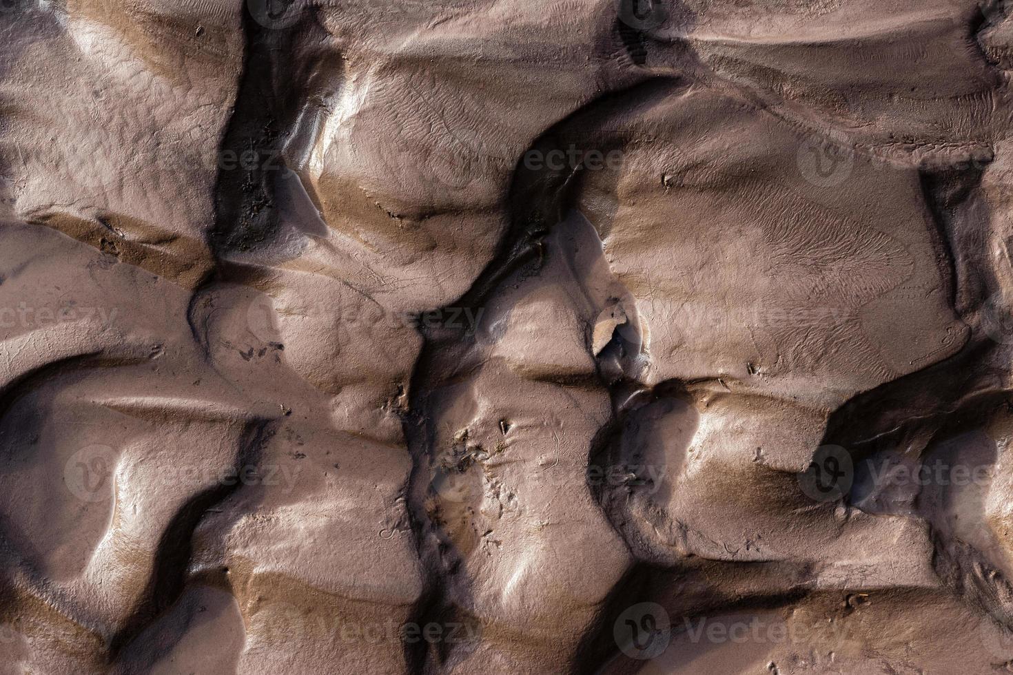 Glacial riverbank shore with wet black silt sand mud photo