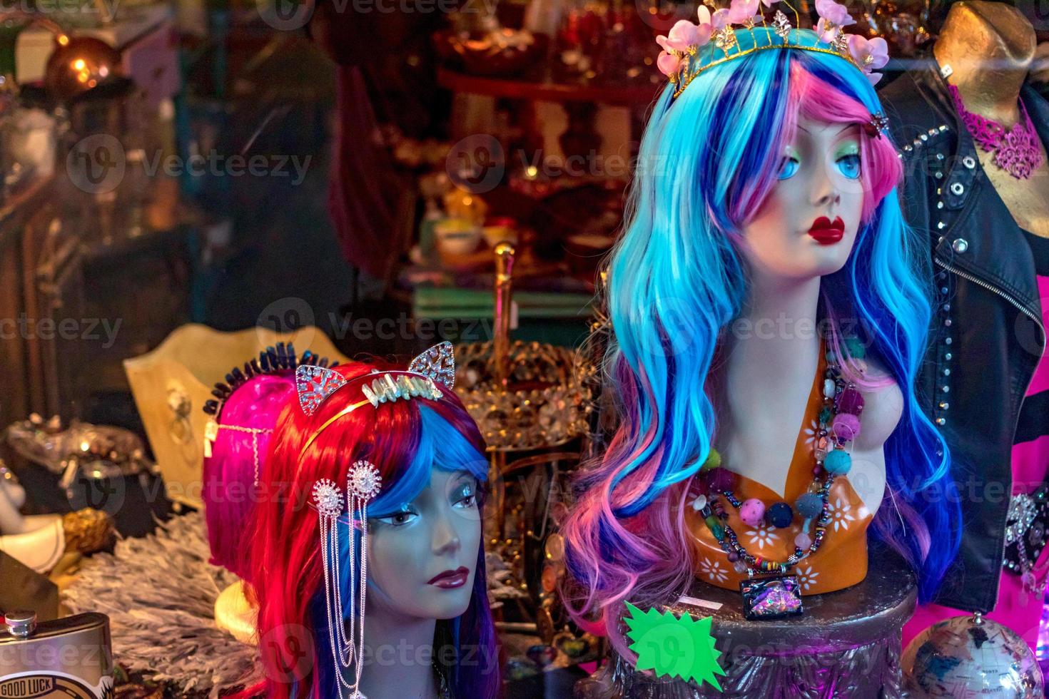 Curio antique shop window displaying mermaid wigs photo