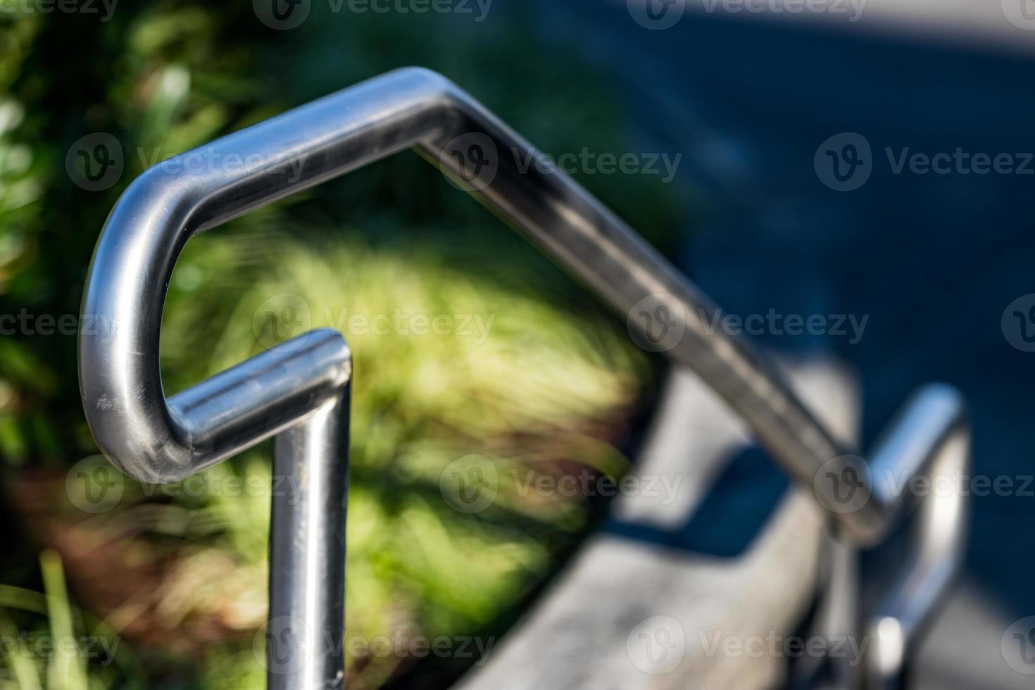 Stainless steel hand rail with grass in the background photo
