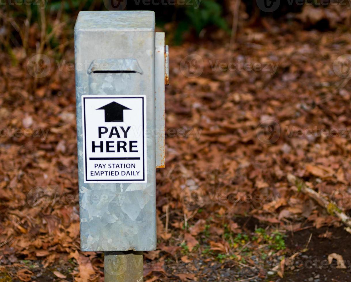 Park pay station drop box with grass and brown leaves photo