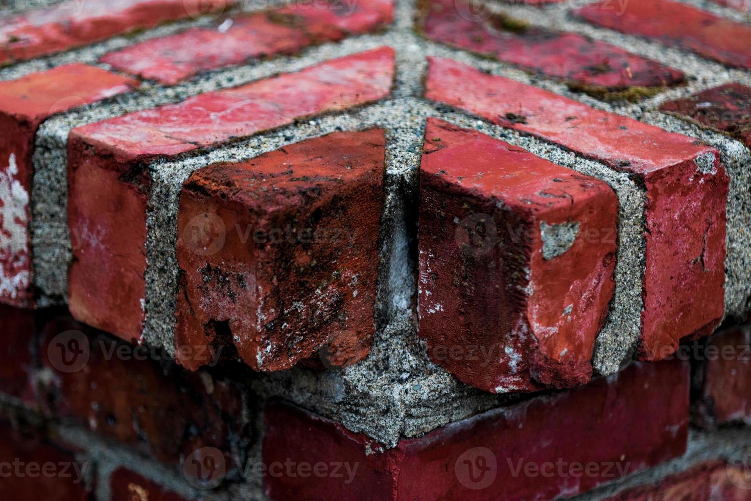 Worn aged red brick corner with a missing piece photo
