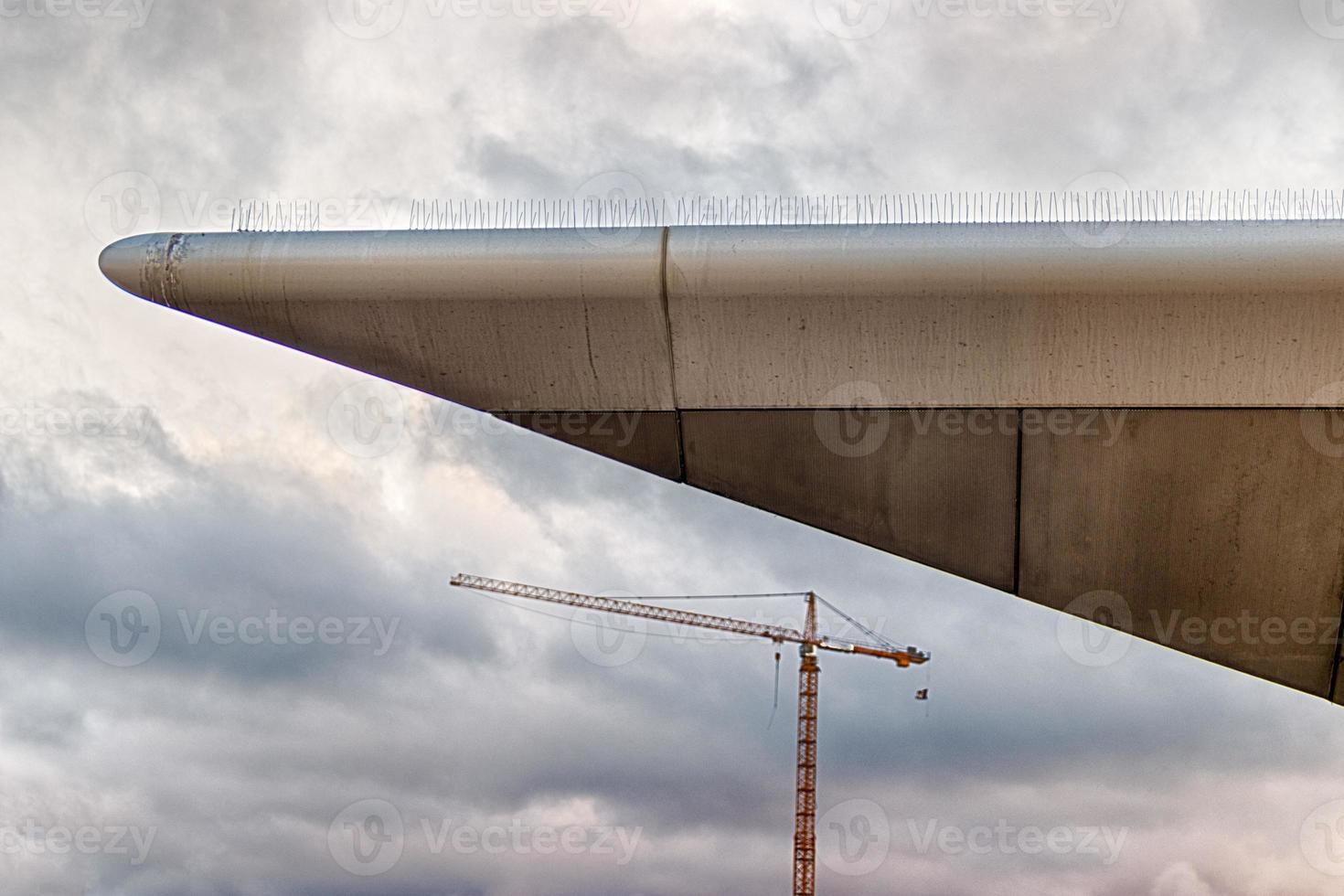 Abstract modern building corner with a large construction crane photo