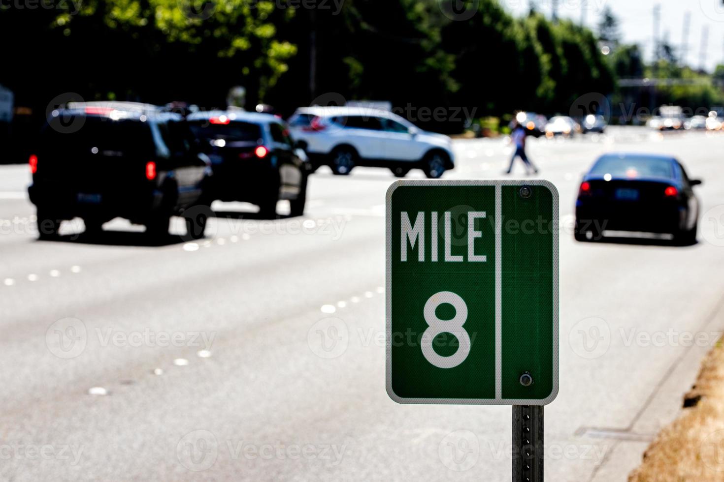 marcador de milla 8 firmar en un puesto con tráfico y una carretera foto