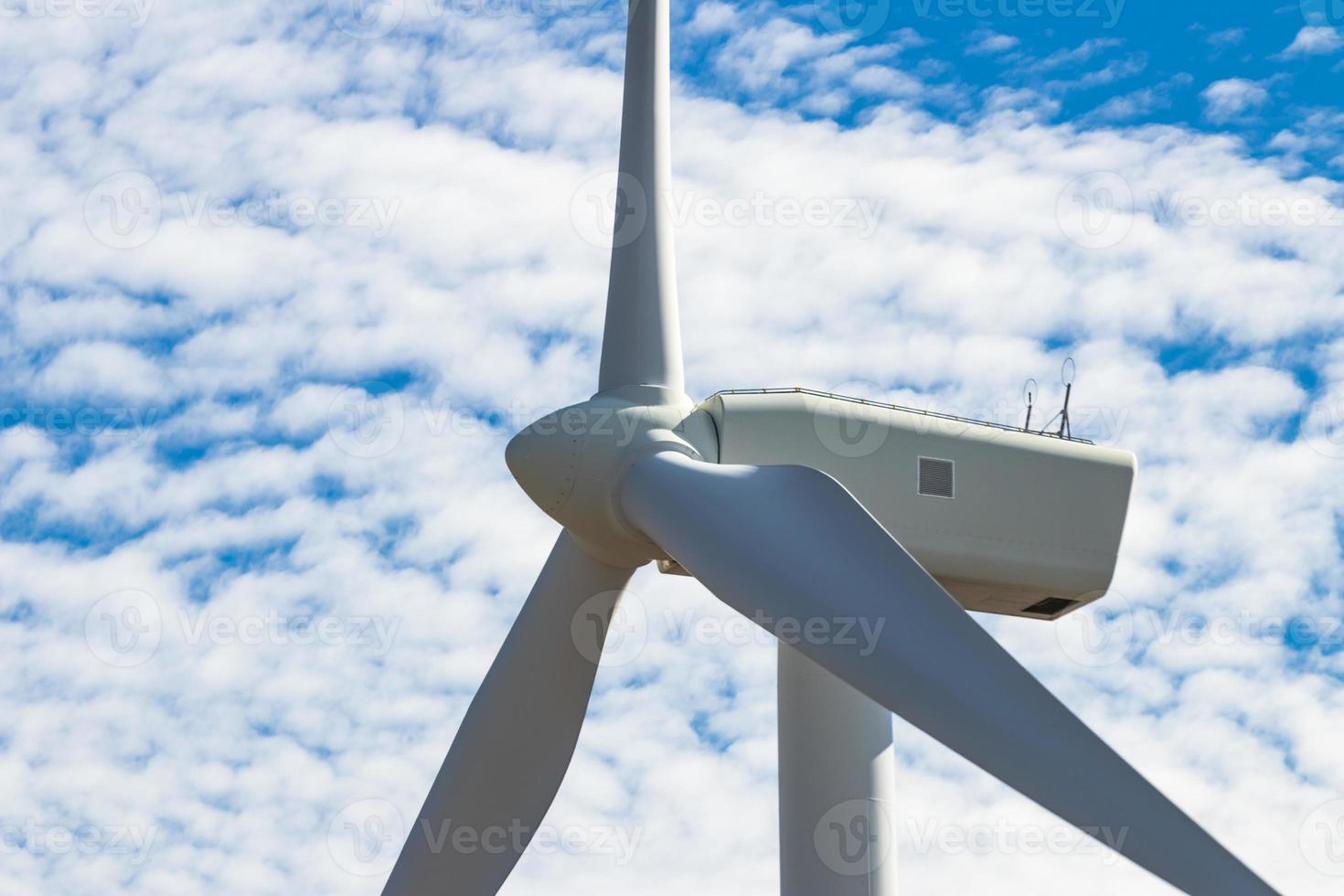 Green sustainable energy windmill power turbine electricity generators on rolling hills with clouds and blue sky photo