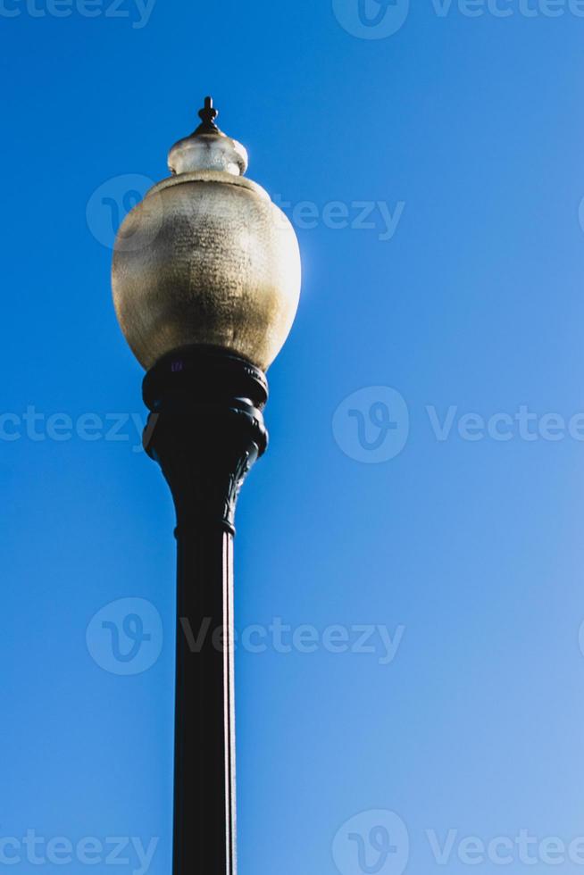 Old fashioned retro street lamps against a blue sky photo
