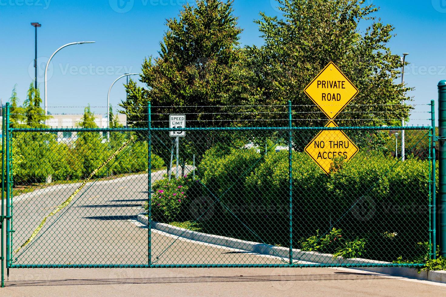 Private road no through access signs behind a fence photo
