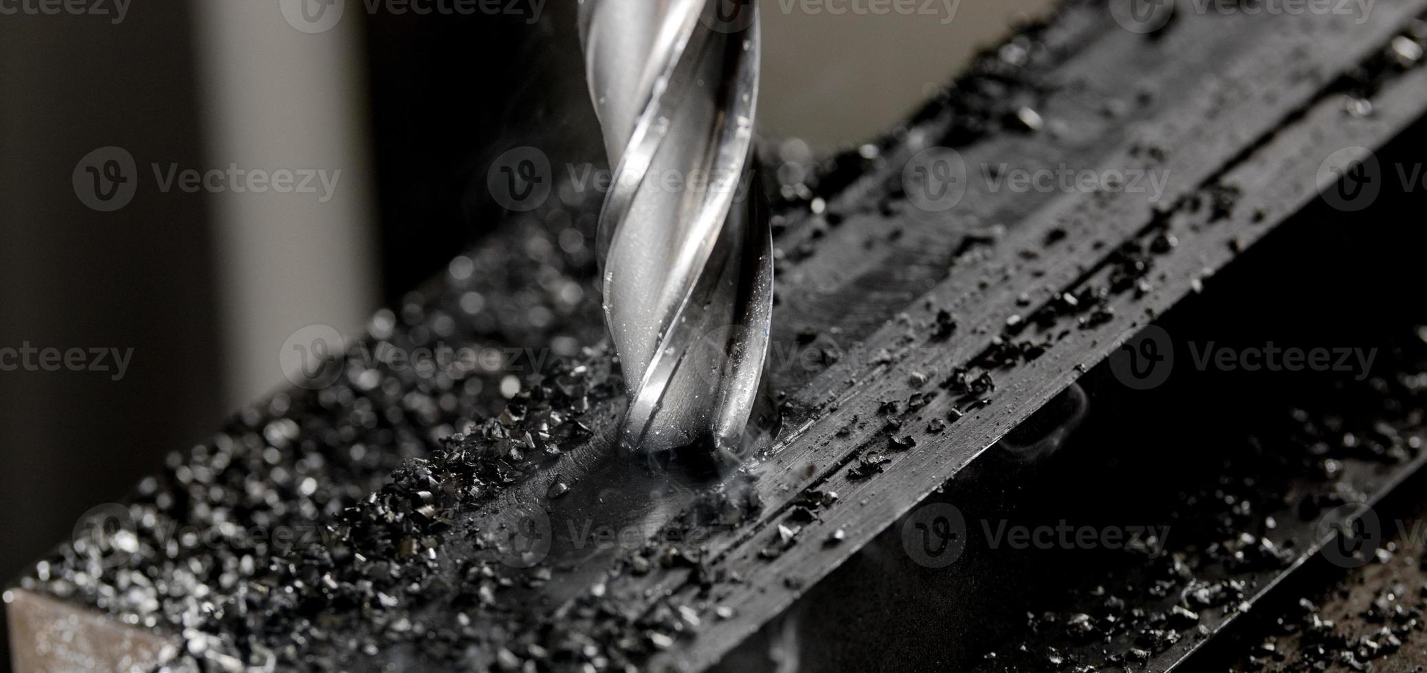 Bridgeport CNC end mill finishing a stack of steel plate with metal filings chips around photo