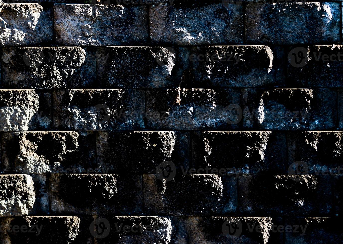Aged worn grungy cement block wall with dirt and moss photo