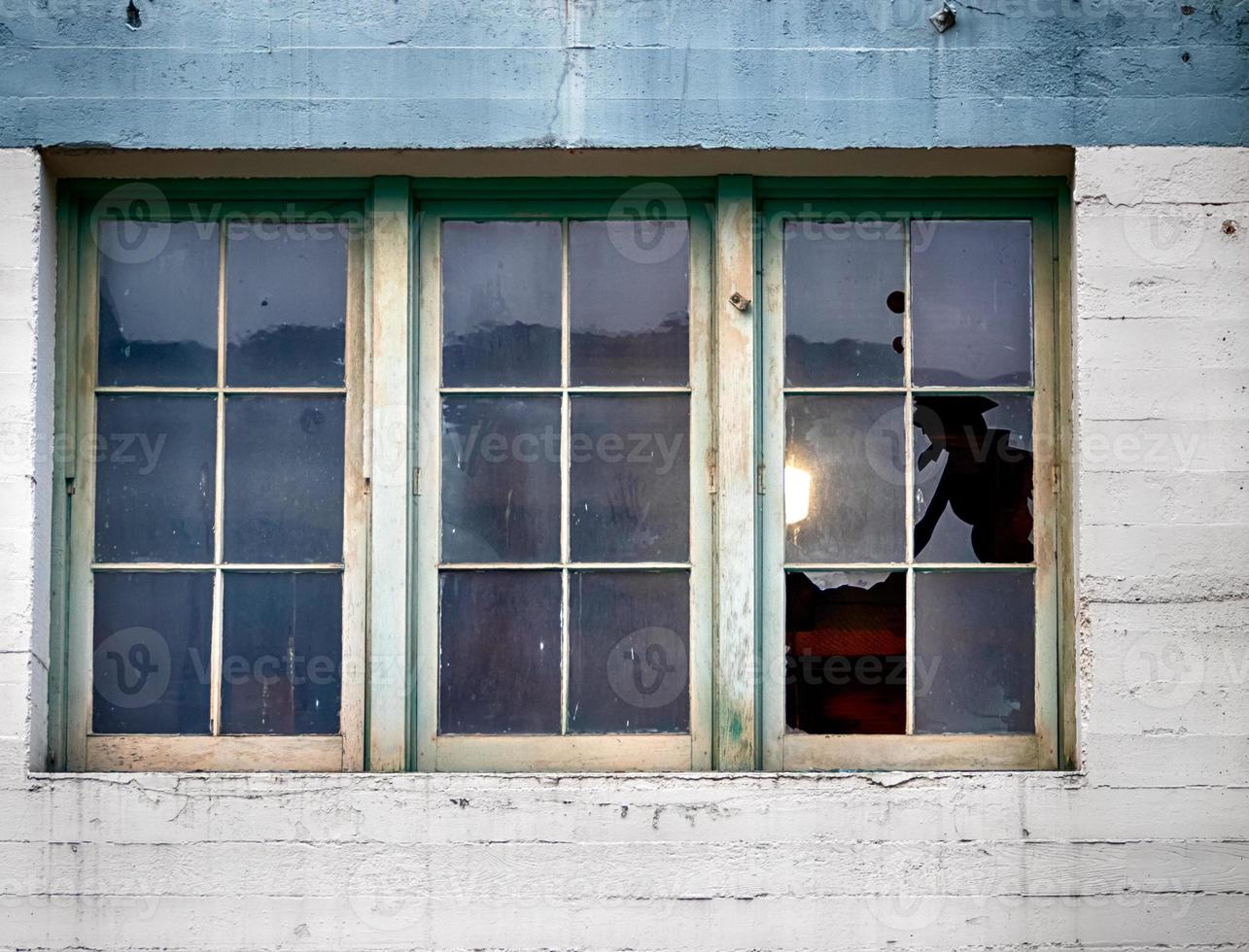 Old building window with panes and broken glass photo