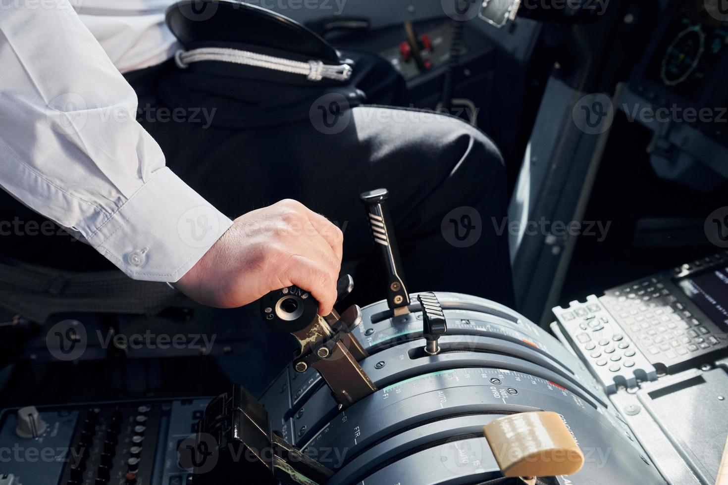Side view. Pilot in formal wear sits in the cockpit and controls airplane photo